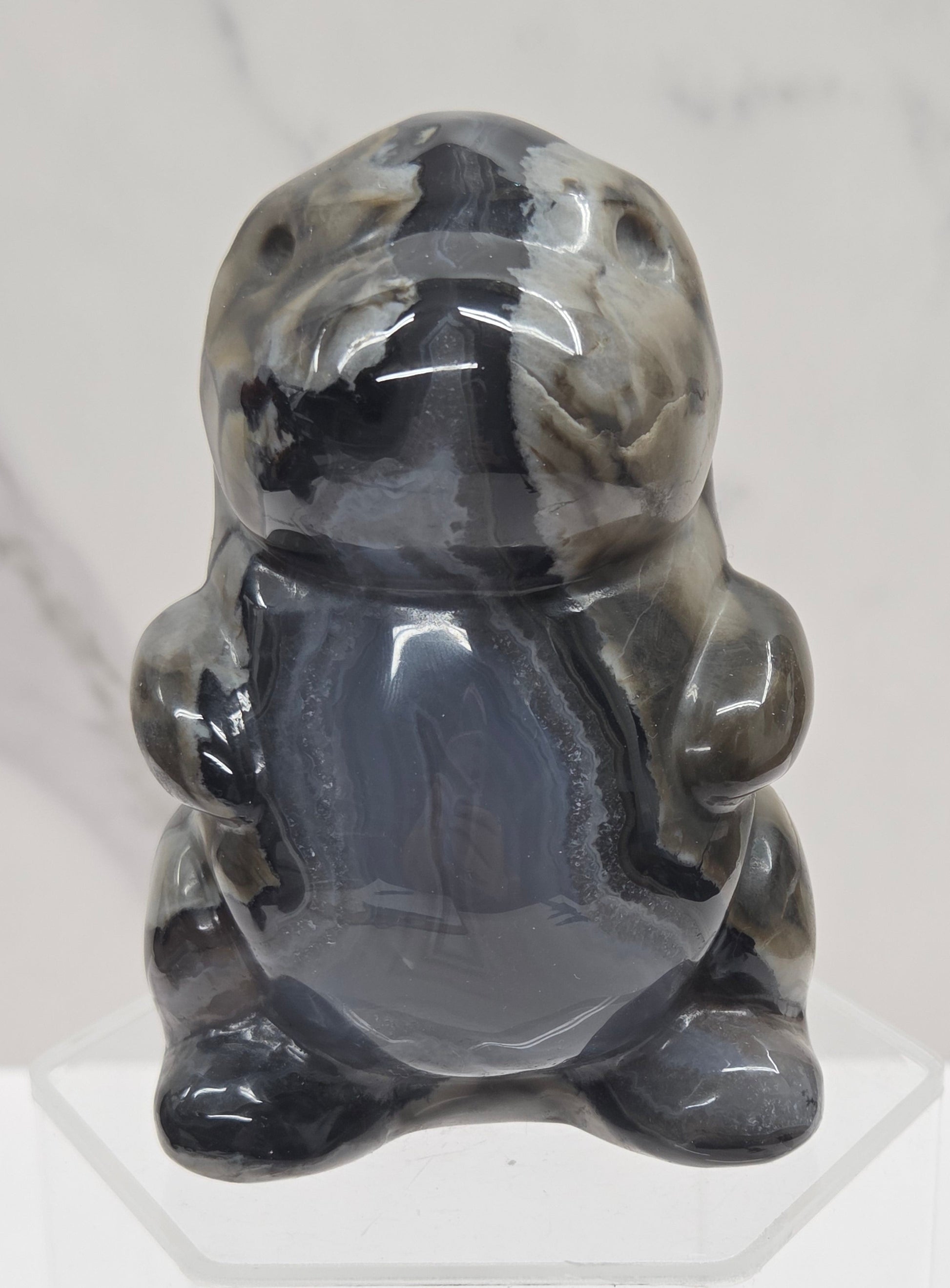 Volcano Agate cute dinosaur like carving on a white background