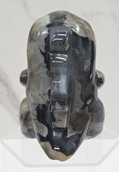 Volcano Agate cute dinosaur like carving on a white background