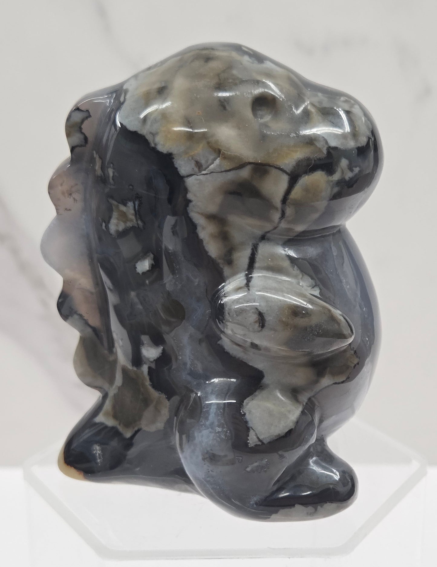 Volcano Agate cute dinosaur like carving on a white background