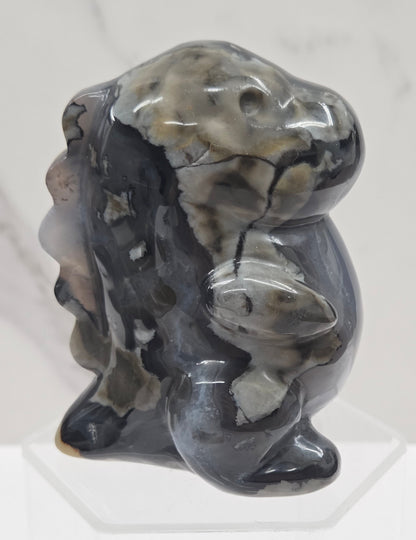 Volcano Agate cute dinosaur like carving on a white background