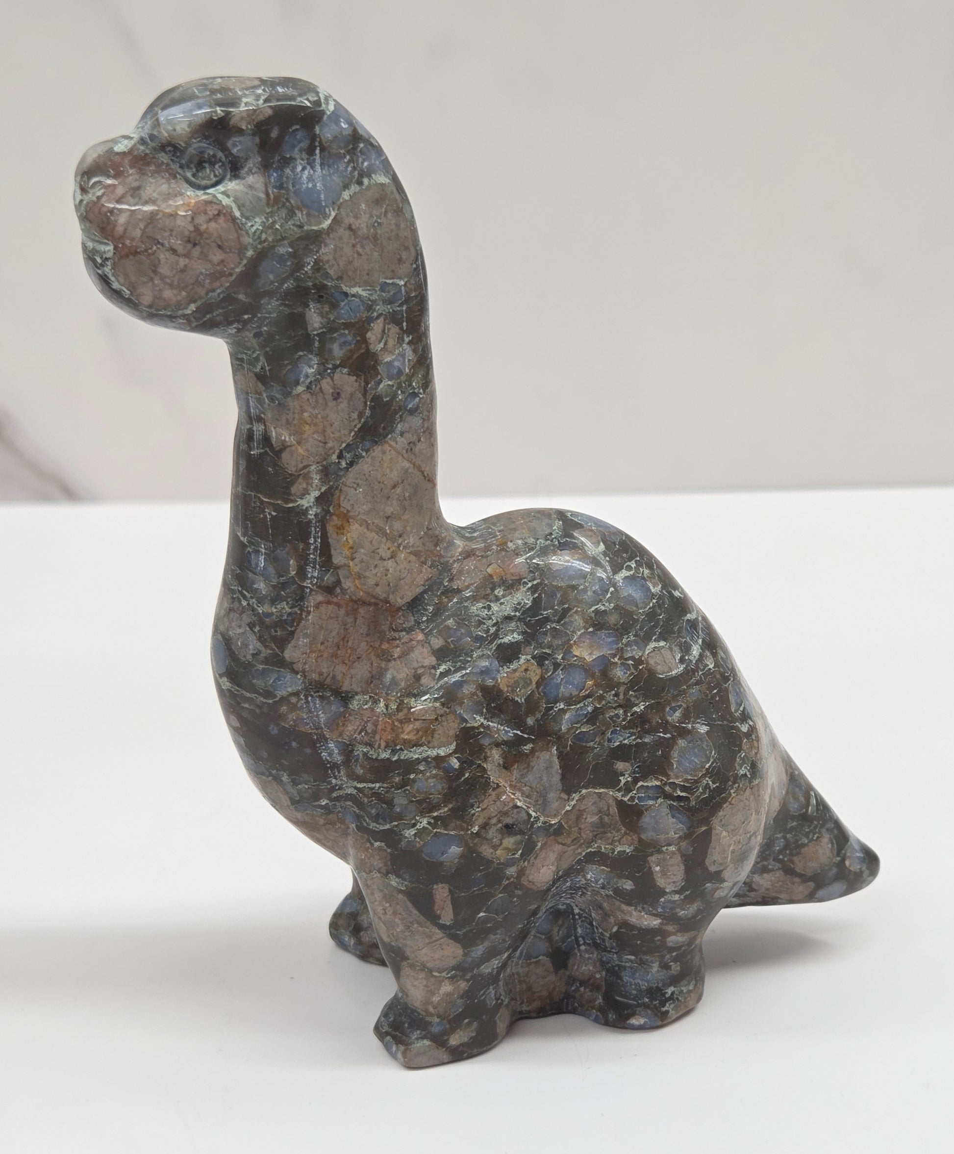 Decorative Que Sera dinosaur carving on a white background