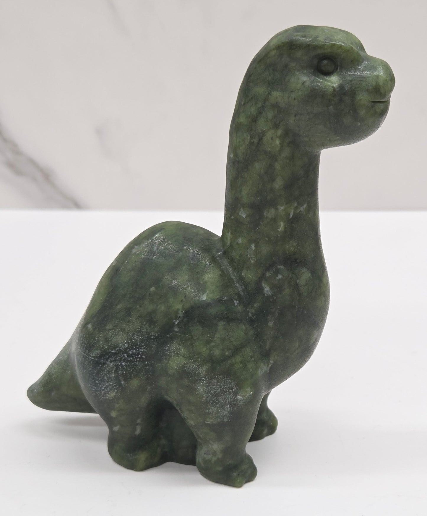 Decorative Green Jade dinosaur carving on a white background
