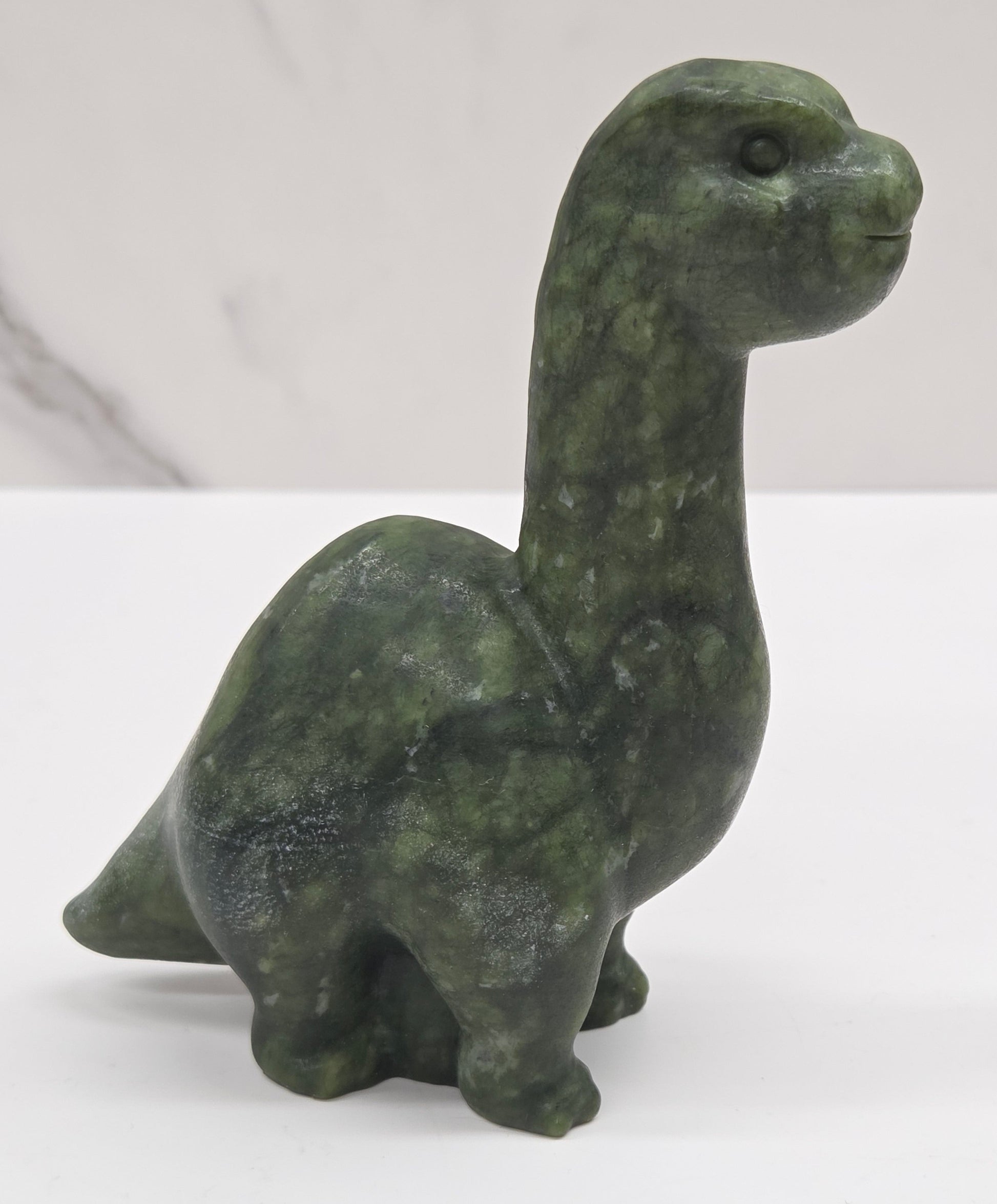 Decorative Green Jade dinosaur carving on a white background