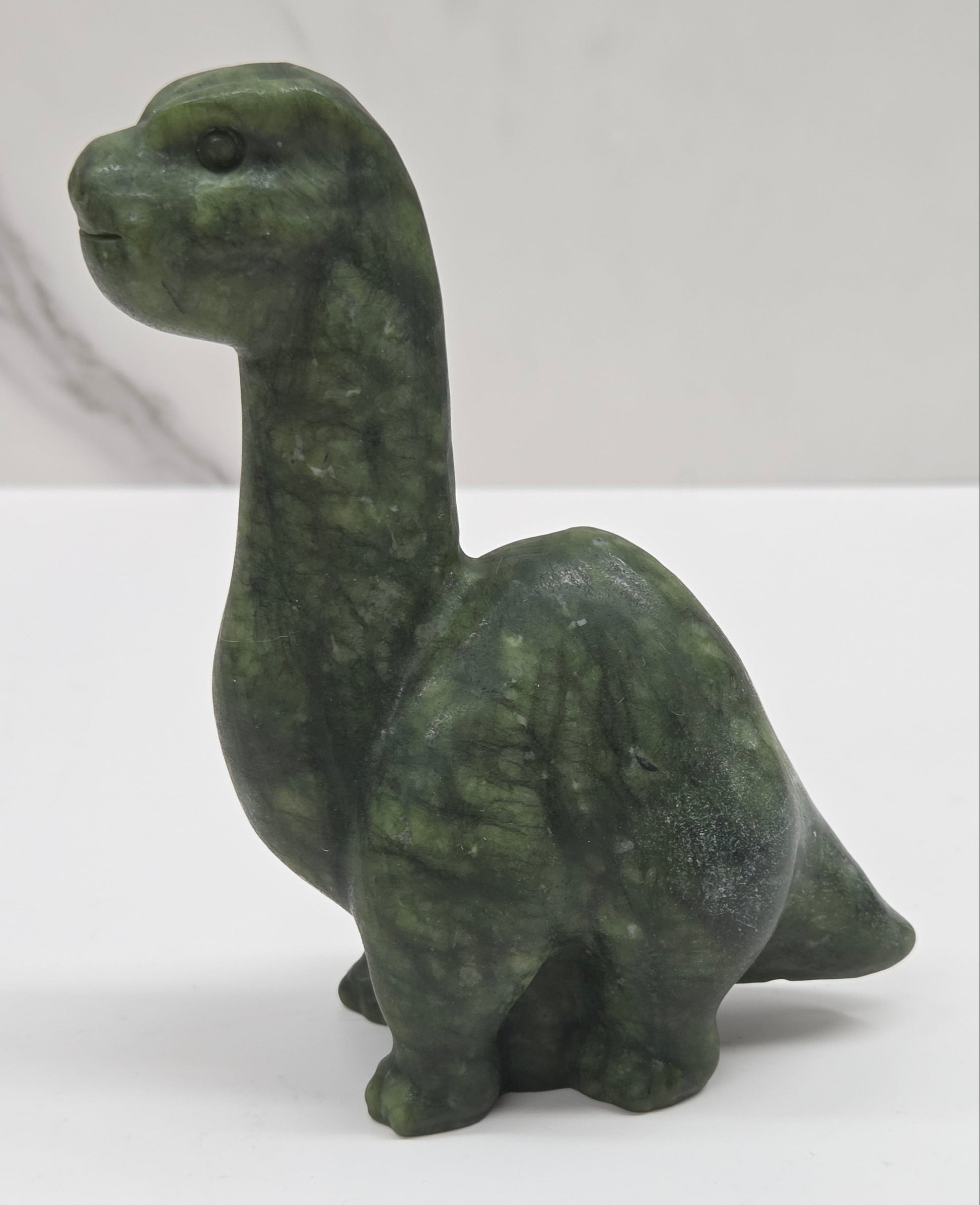 Decorative Green Jade dinosaur carving on a white background