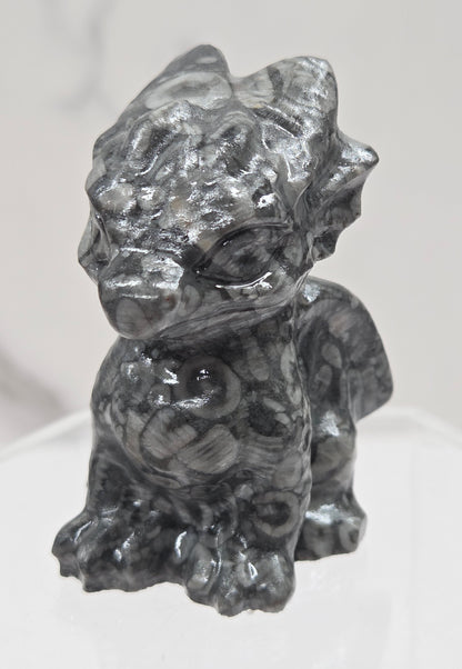 Fossil Shell Jasper crystal dragon carving on a white background