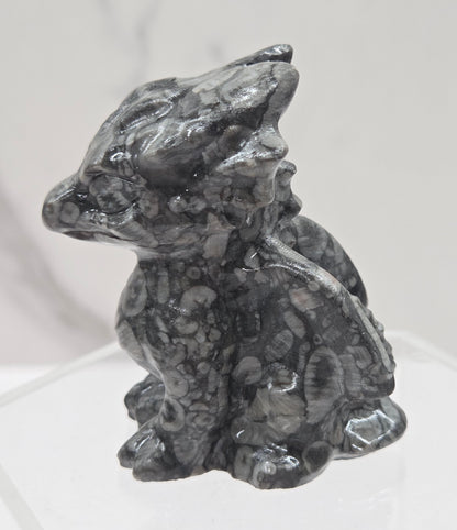 Fossil Shell Jasper crystal dragon carving on a white background