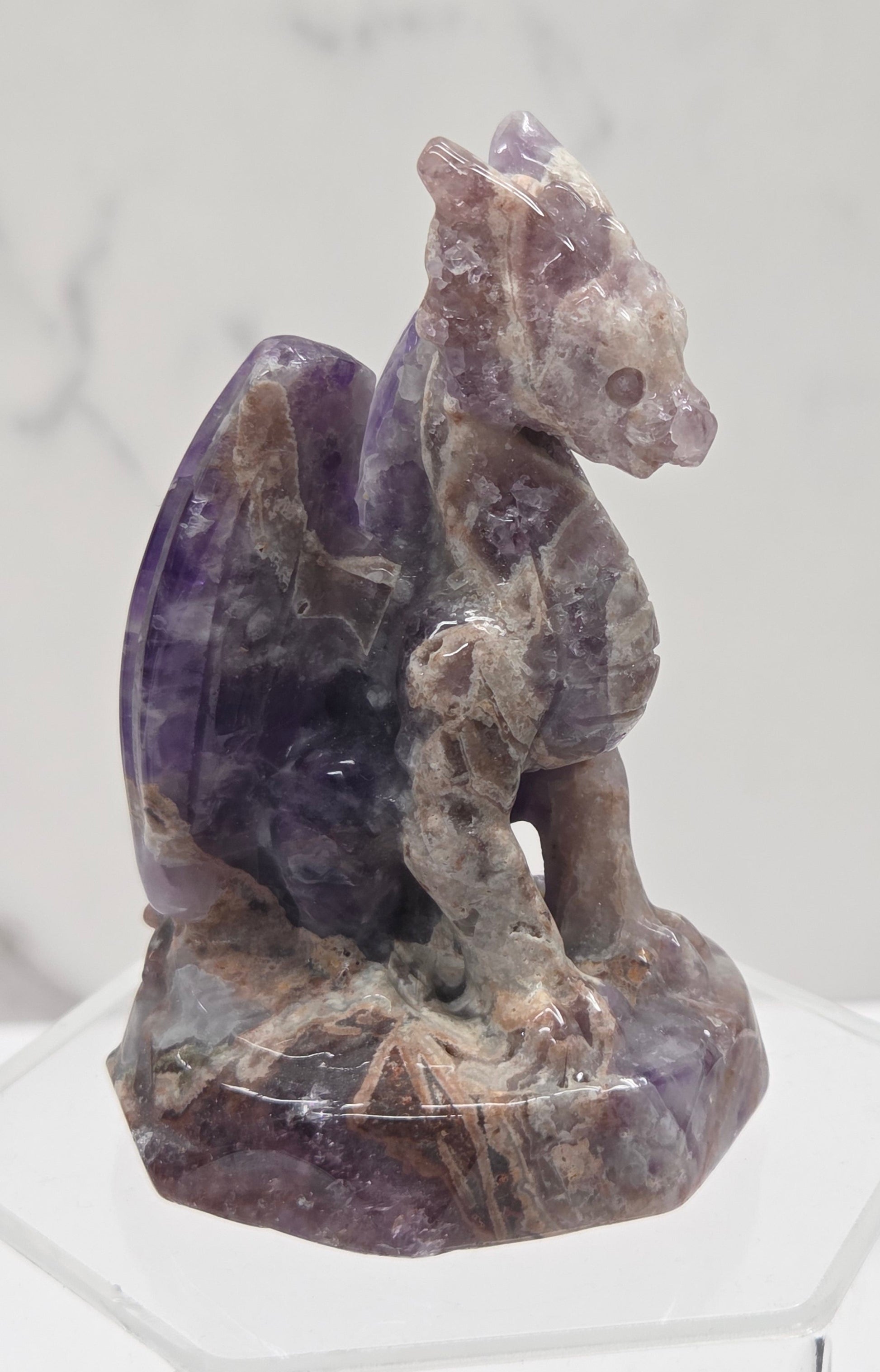Amethyst crystal sculpture of a dragon on a white background