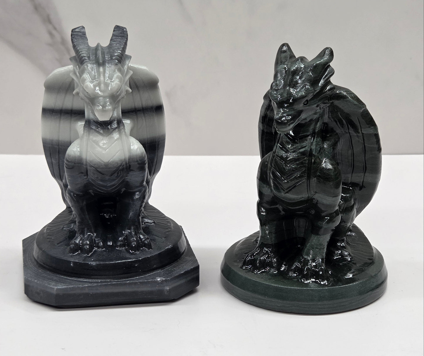 Set of 2 crystal dragon sculptures, one black and white striped, one green, on a white background