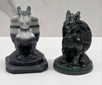 Set of 2 crystal dragon sculptures, one black and white striped, one green, on a white background