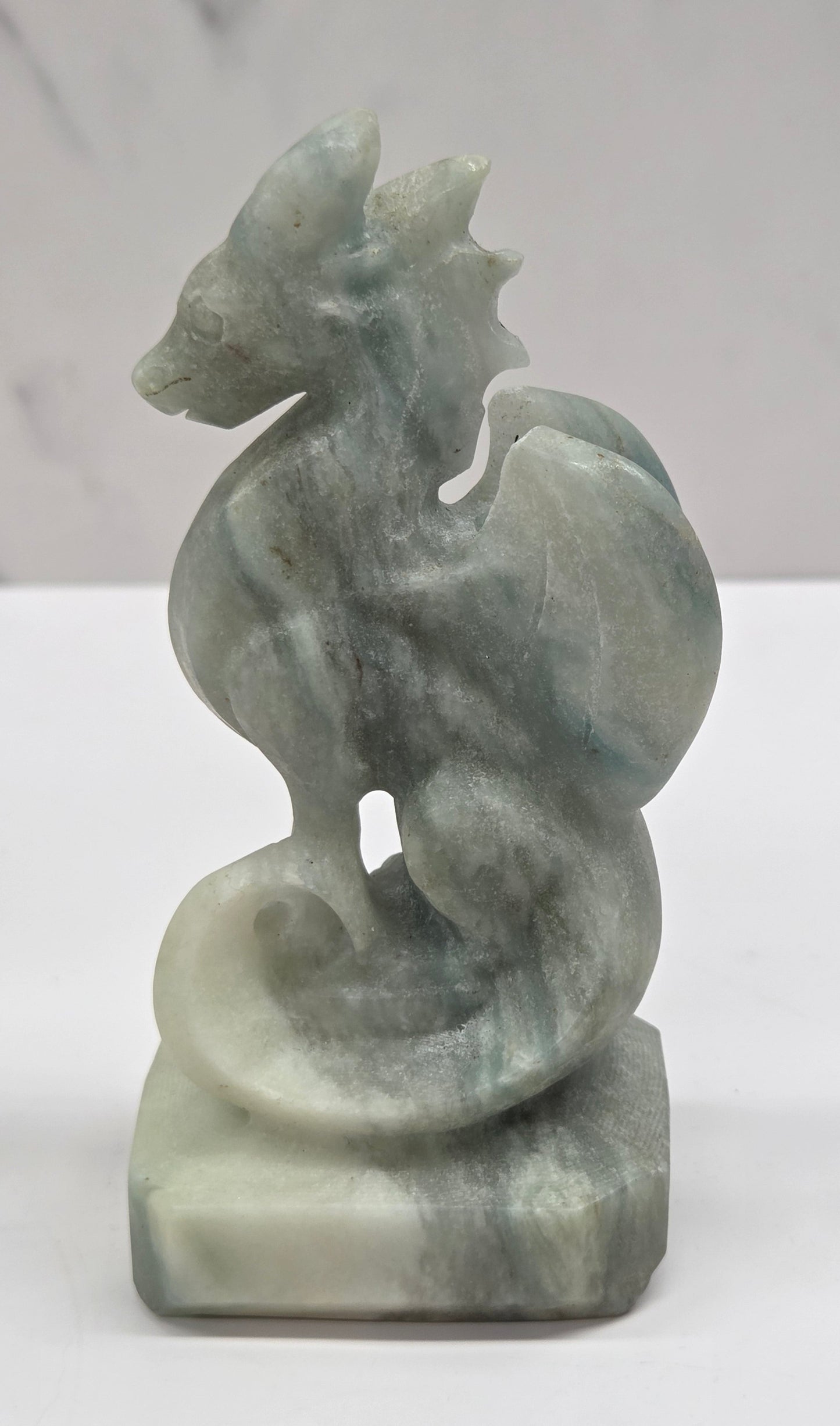 Blue Calcite crystal dragon sculpture on a white background