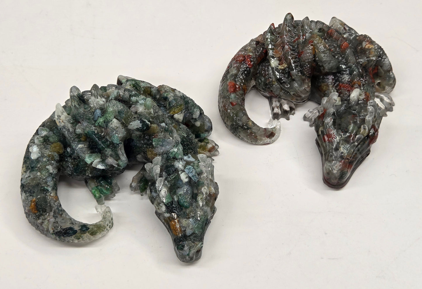 Two resin with crystal chip carvings of dragons on a white background