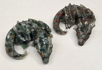 Two resin with crystal chip carvings of dragons on a white background