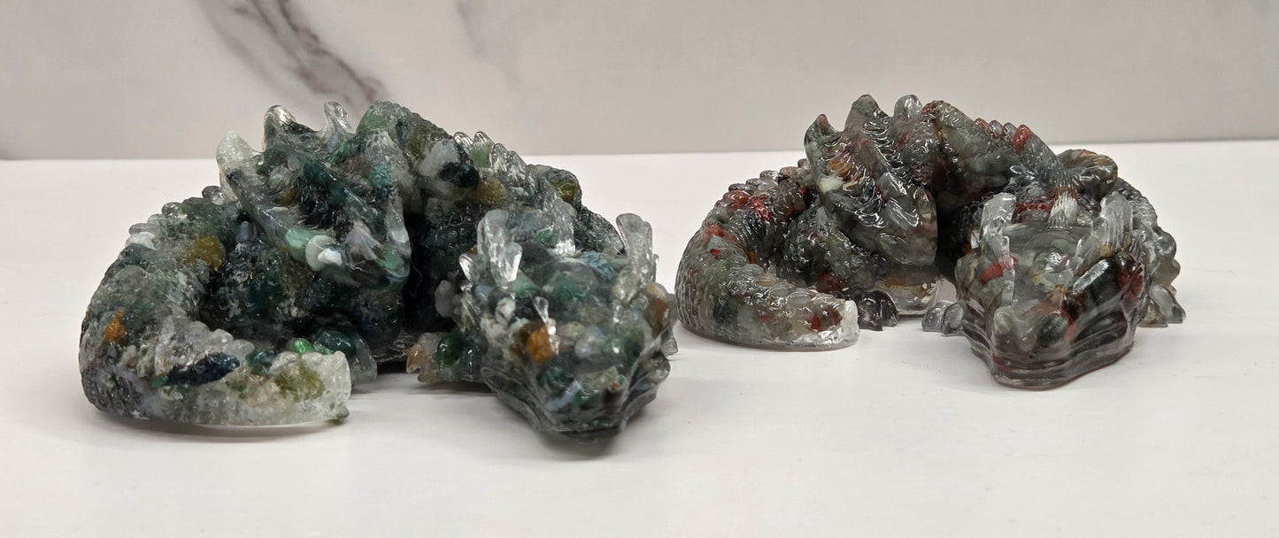 Two resin with crystal chip carvings of dragons on a white background