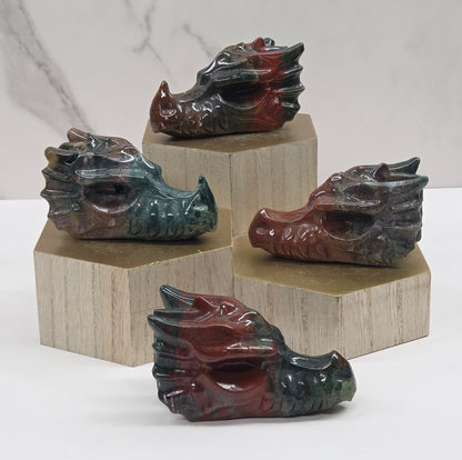Four dragon-shaped carvings on a wooden block against a marble background