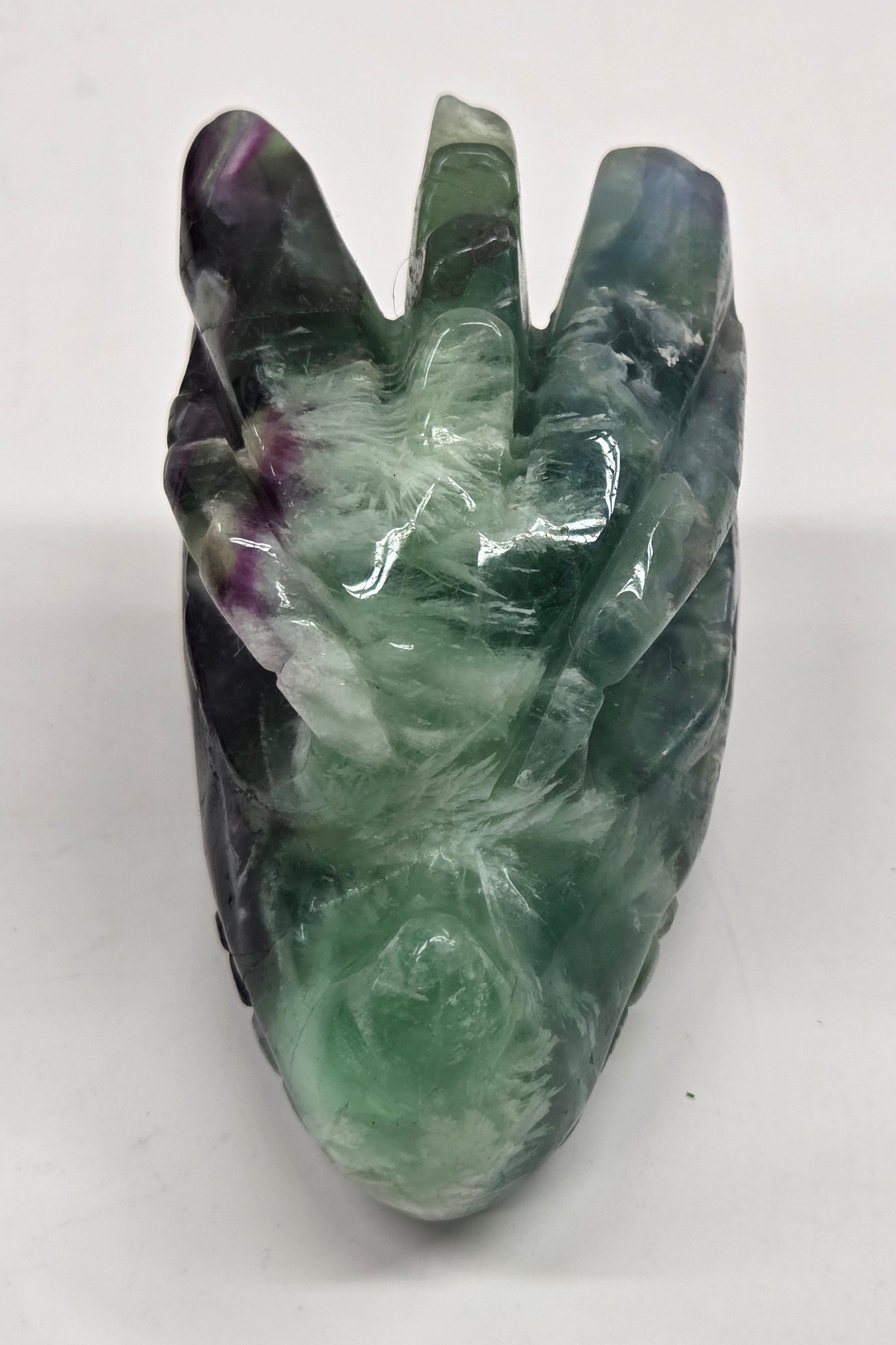 Green crystal dragon head sculpture on a white background