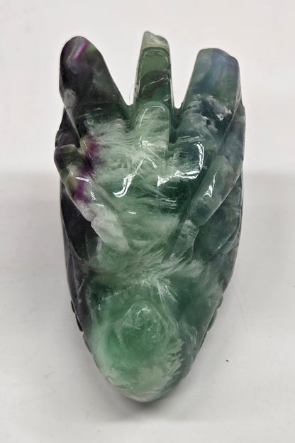 Green crystal dragon head sculpture on a white background