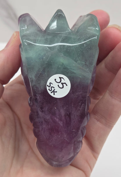 Underside of fluorite dragon head sculpture on a white surface