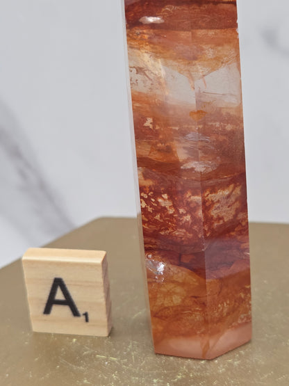 Fire Quartz crystal point with 'A1' label on a marble surface