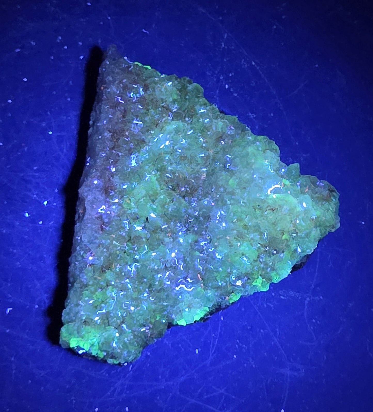 A calcite specimen under UV light with a neutral background