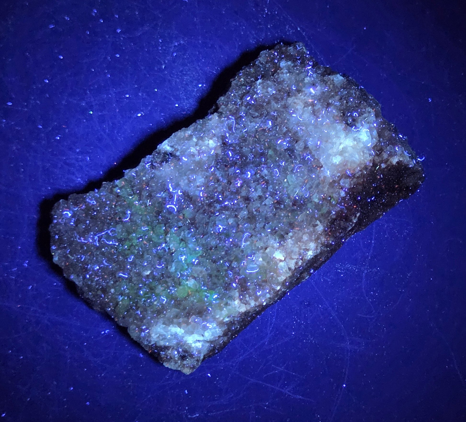 A calcite specimen under UV light with a neutral background