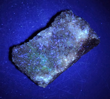 A calcite specimen under UV light with a neutral background