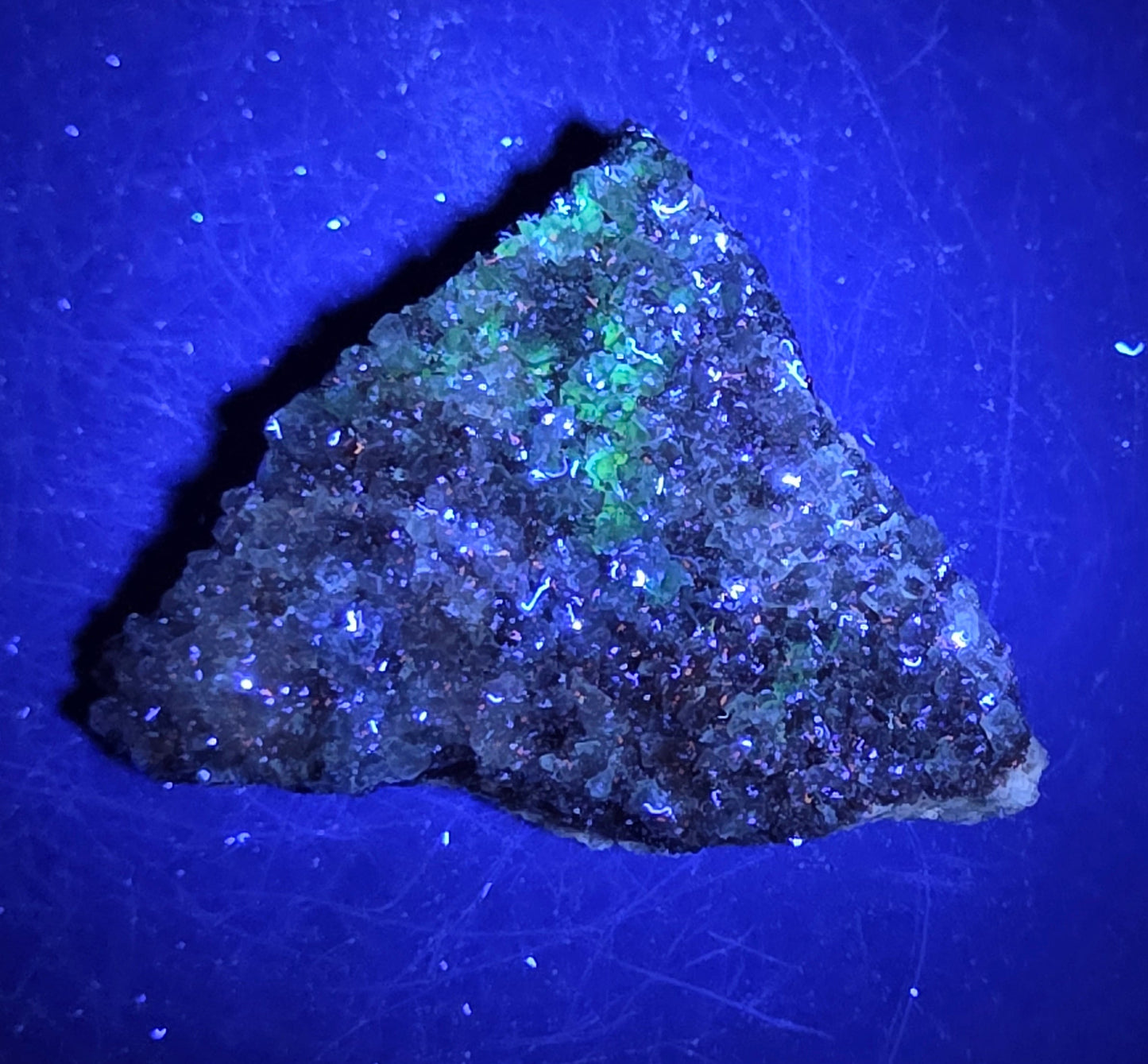 A calcite specimen under UV light with a neutral background