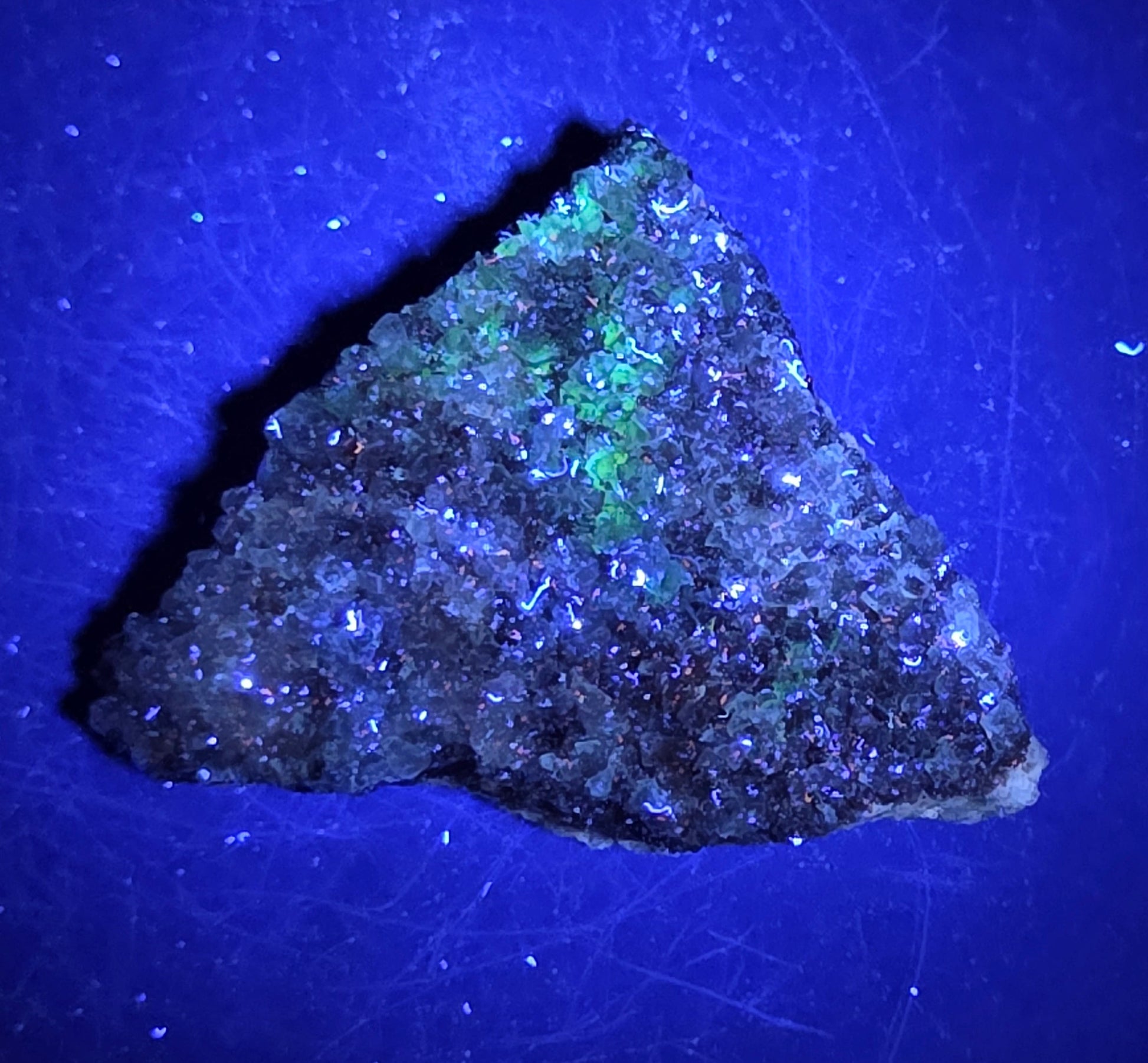 A calcite specimen under UV light with a neutral background