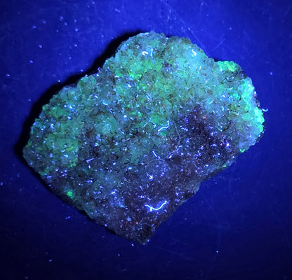 A calcite specimen under UV light with a neutral background