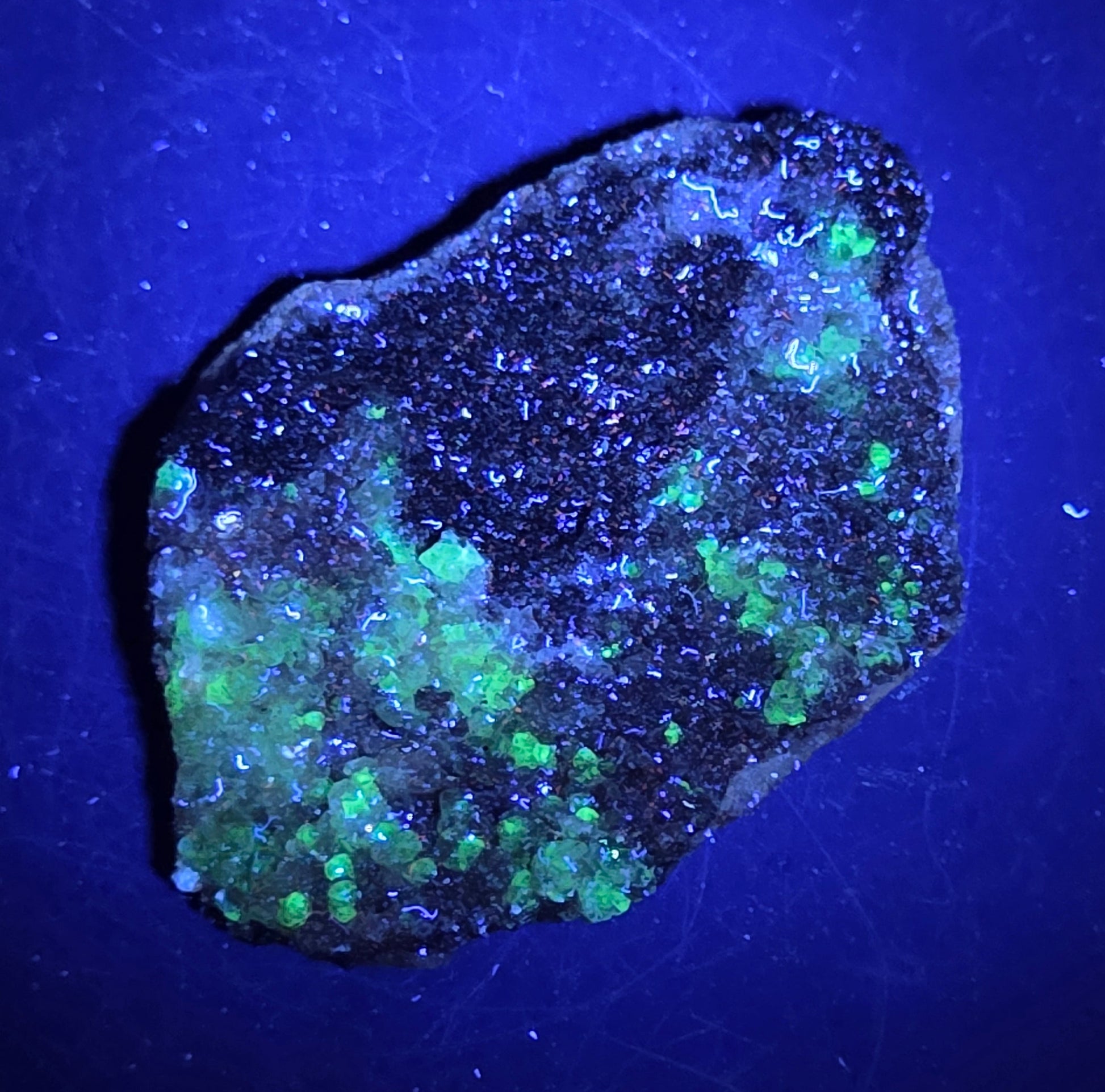 A calcite specimen under UV light with a neutral background