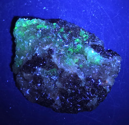 A calcite specimen under UV light with a neutral background