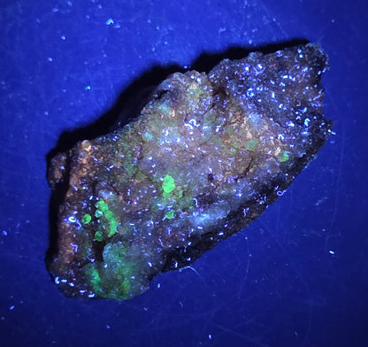 A calcite specimen under UV light with a neutral background