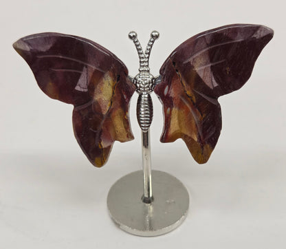 Butterfly-shaped mookaite wings on stands with a marble-like texture against a neutral background