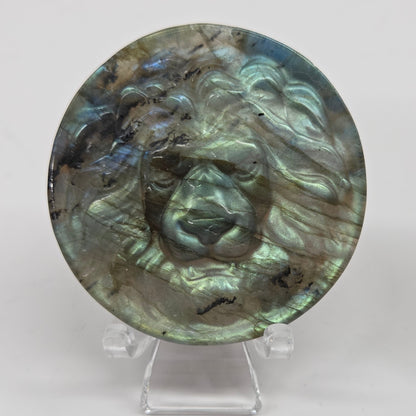 Decorative labradorite coin with a lion carving on a white background