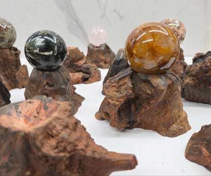 Collection of crystal balls on natural wood bases against a marble background