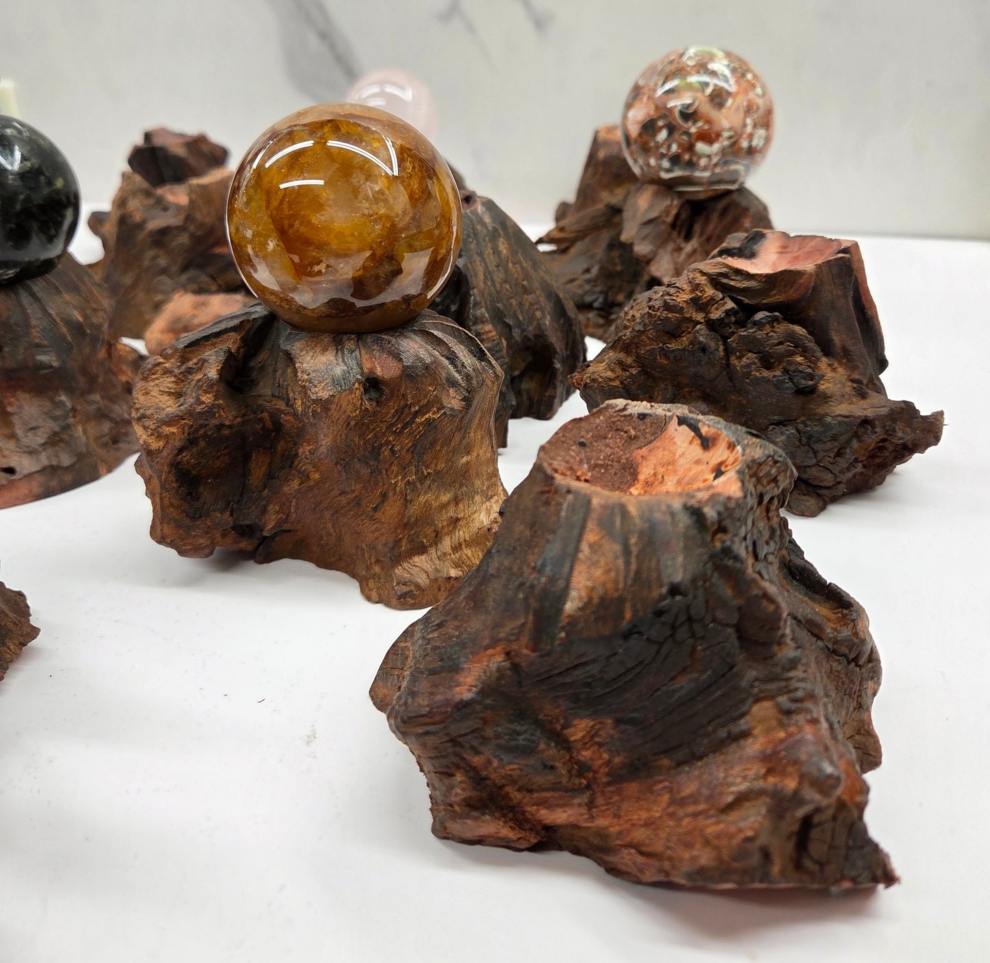 Collection of crystal balls on natural wood bases against a marble background