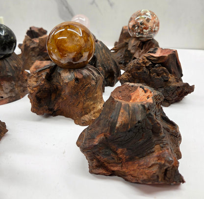 Collection of crystal balls on natural wood bases against a marble background