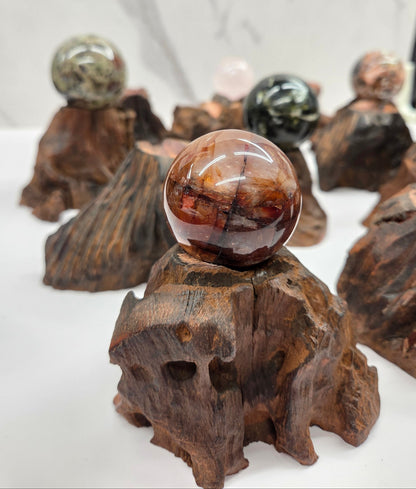 Collection of crystal balls on natural wood bases against a marble background