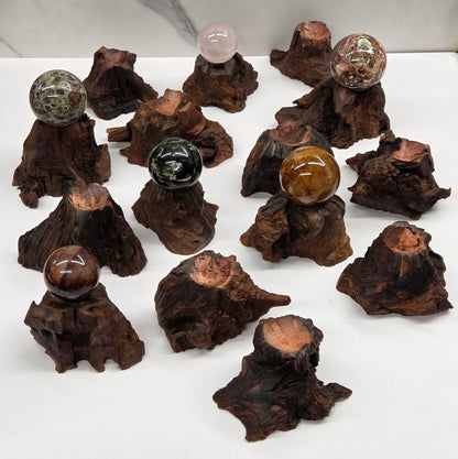 Collection of crystal balls on natural wood bases against a marble background