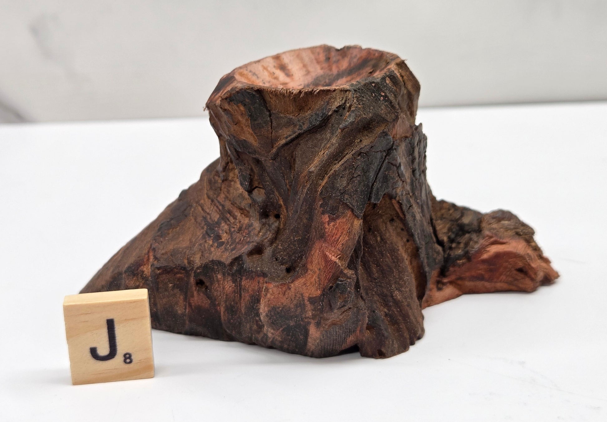 Wooden block with a letter 'J' on a white surface
