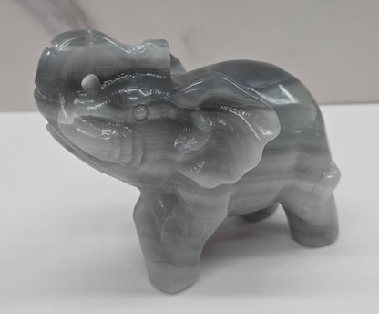 Gray Agate elephant carving on a white surface with a neutral background