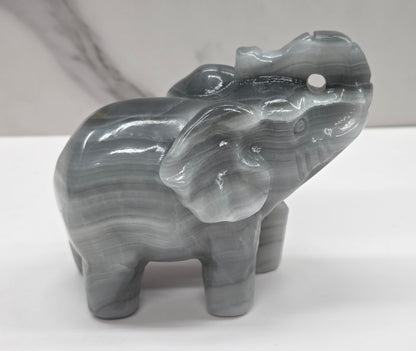 Gray Agate elephant carving on a white surface with a neutral background