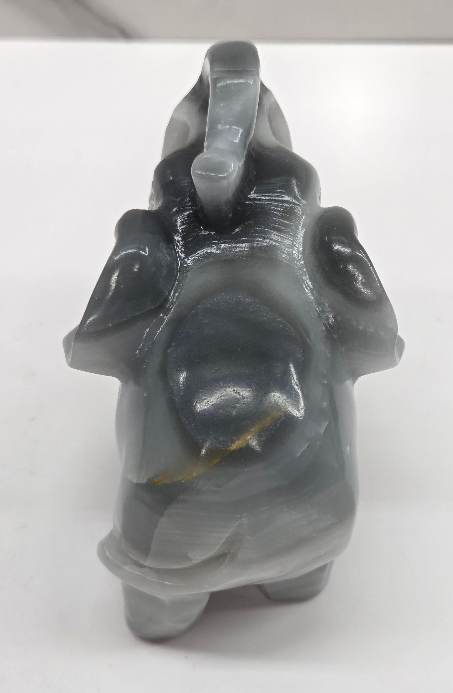 Gray Agate elephant carving on a white surface with a neutral background