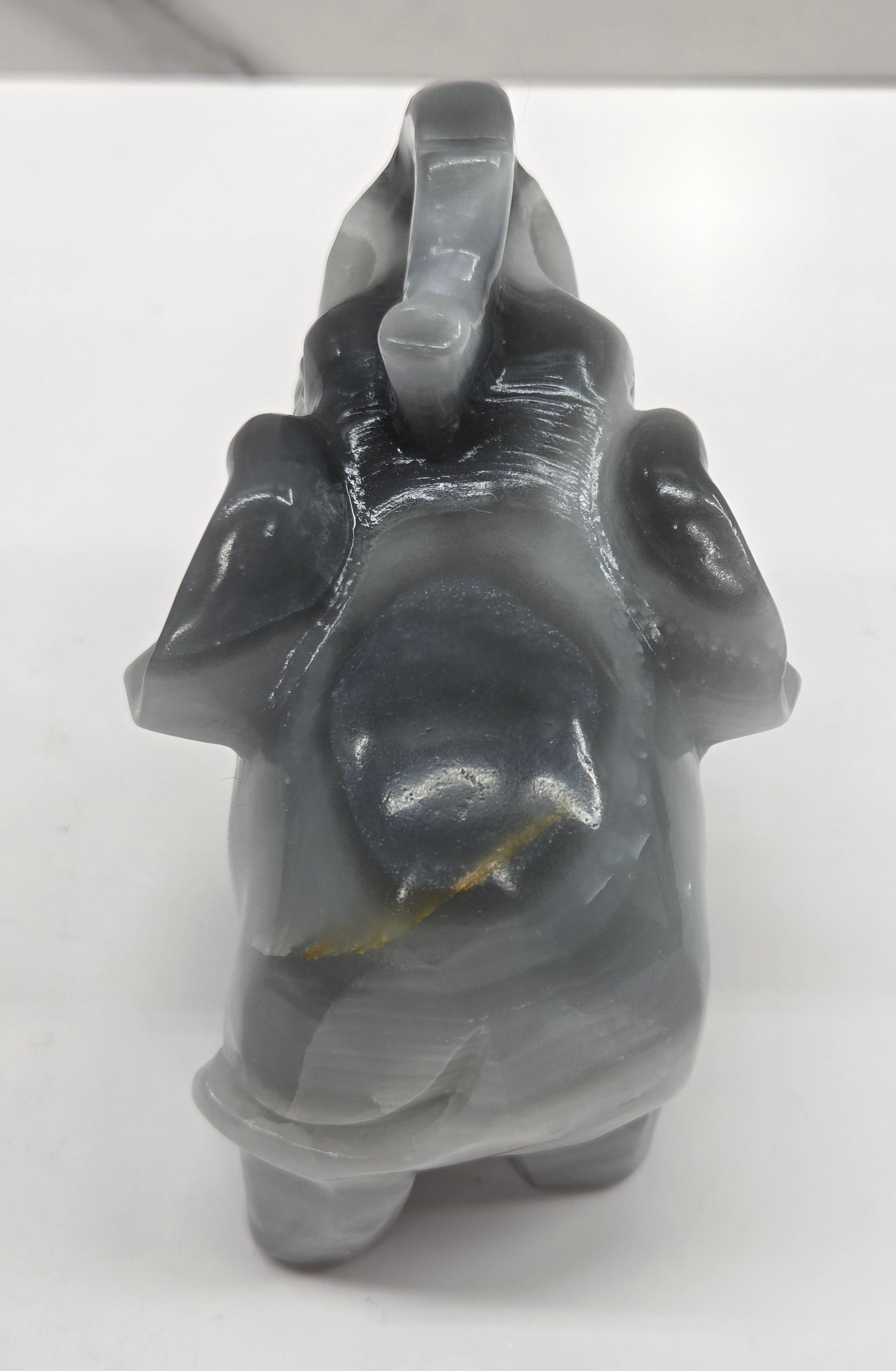 Gray Agate elephant carving on a white surface with a neutral background
