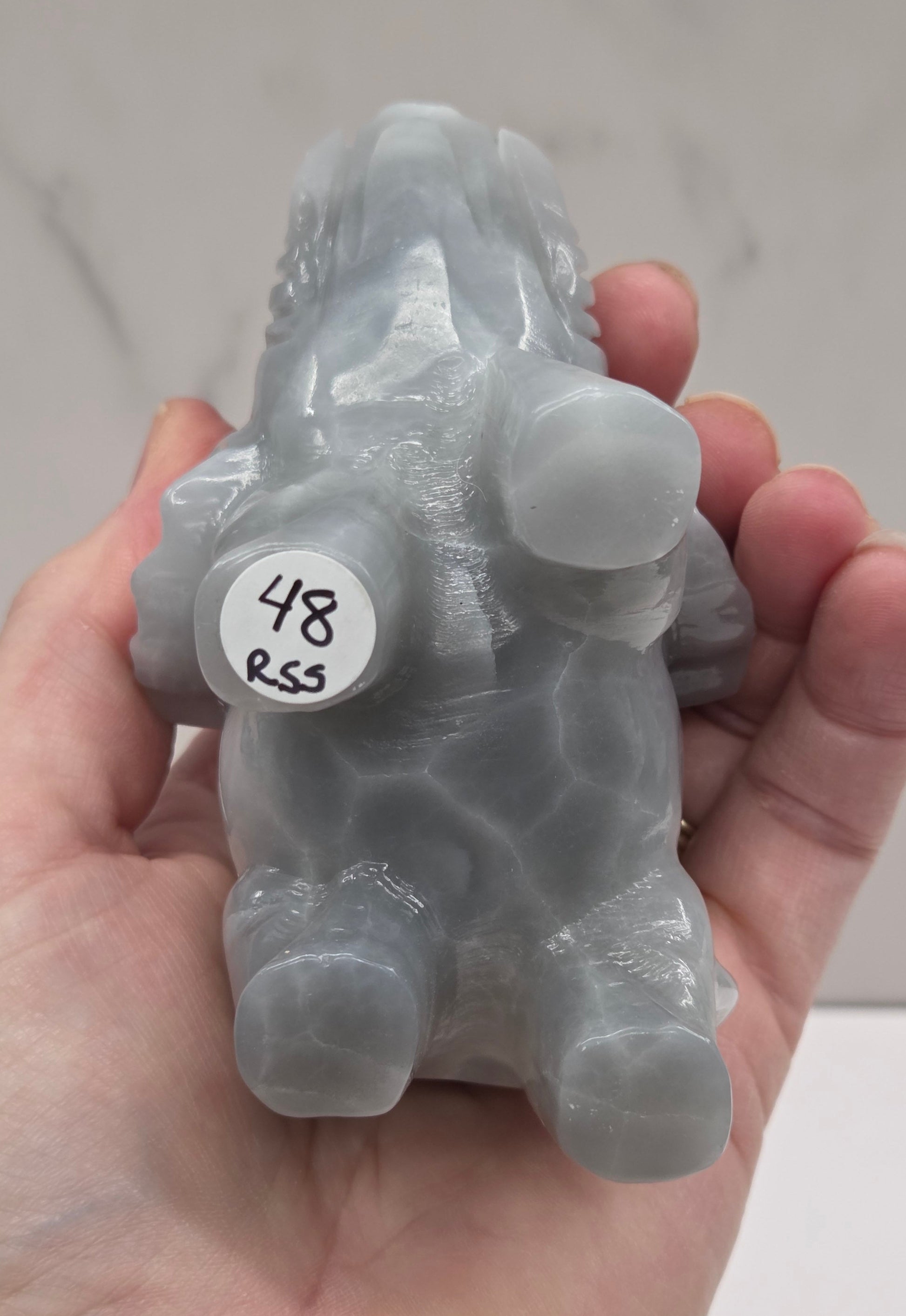 Gray Agate elephant carving on a white surface with a neutral background