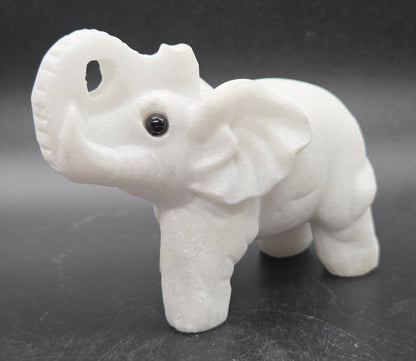 White Jade elephant figurine on a dark gray background