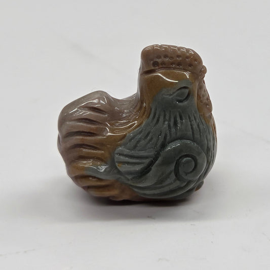 Small multi-colored Alashan Agate carving of a chicken on a white background