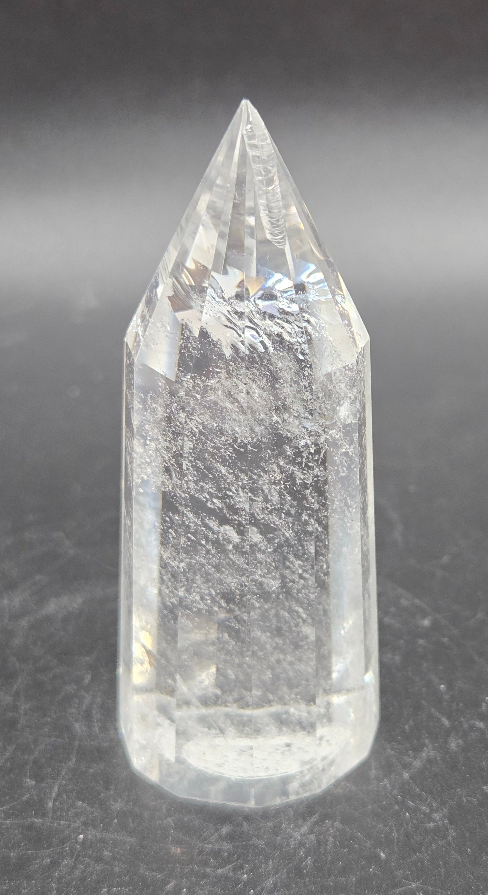 Clear crystal point on a dark textured surface