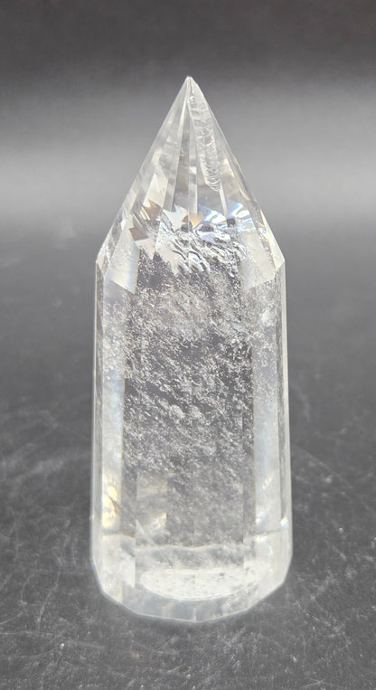 Clear crystal point on a dark textured surface