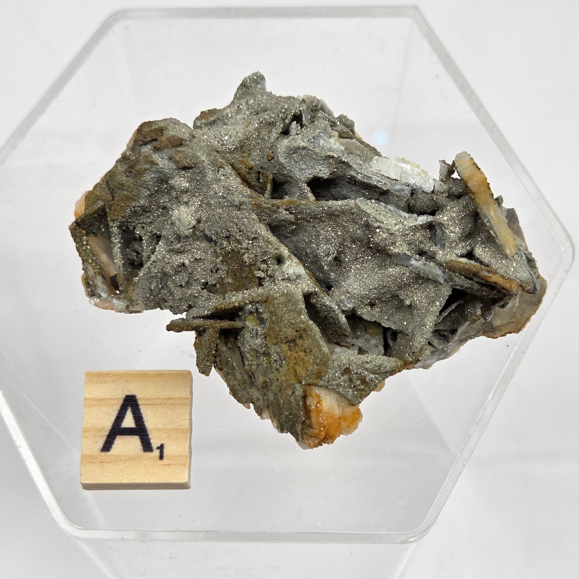 Mineral sample on a clear stand with a wooden label on a white background