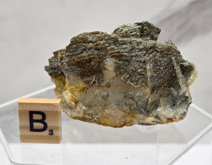 Mineral sample with a wooden label on a white background